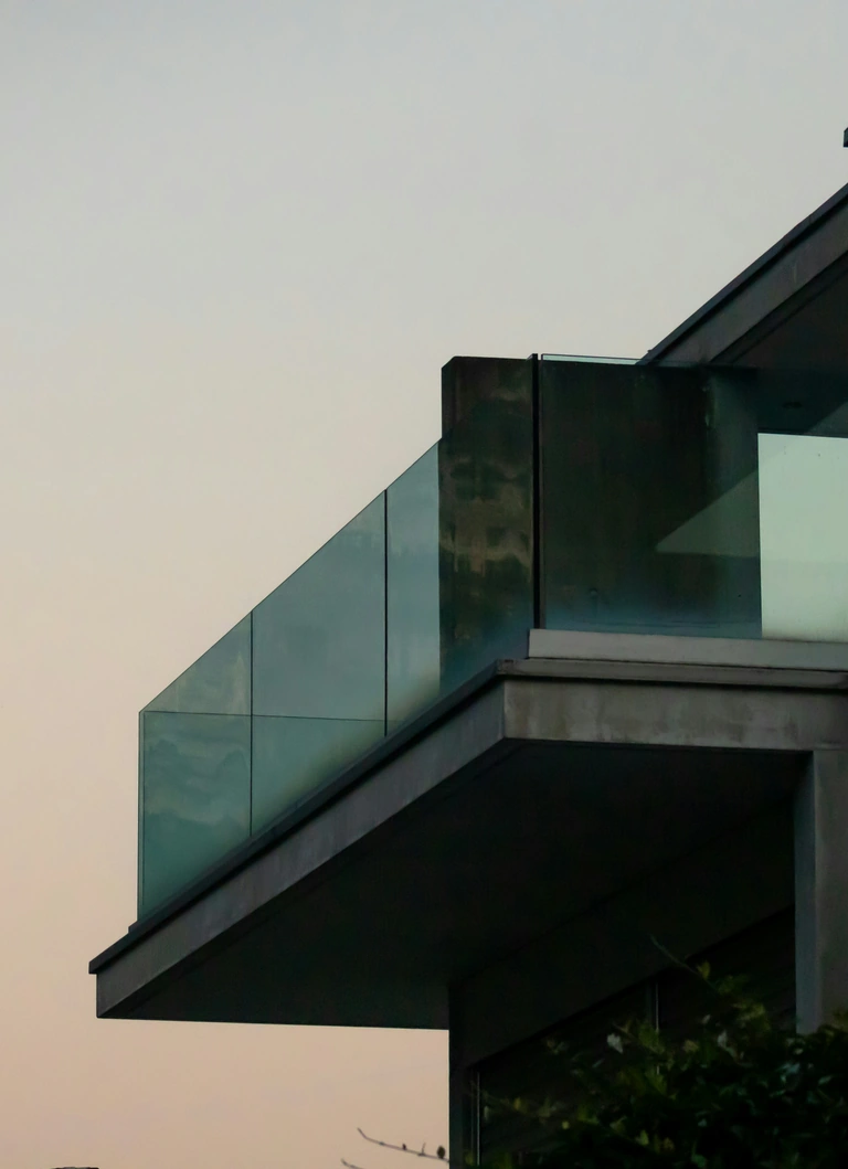 Façade vitrée d'un bâtiment moderne au crépuscule.